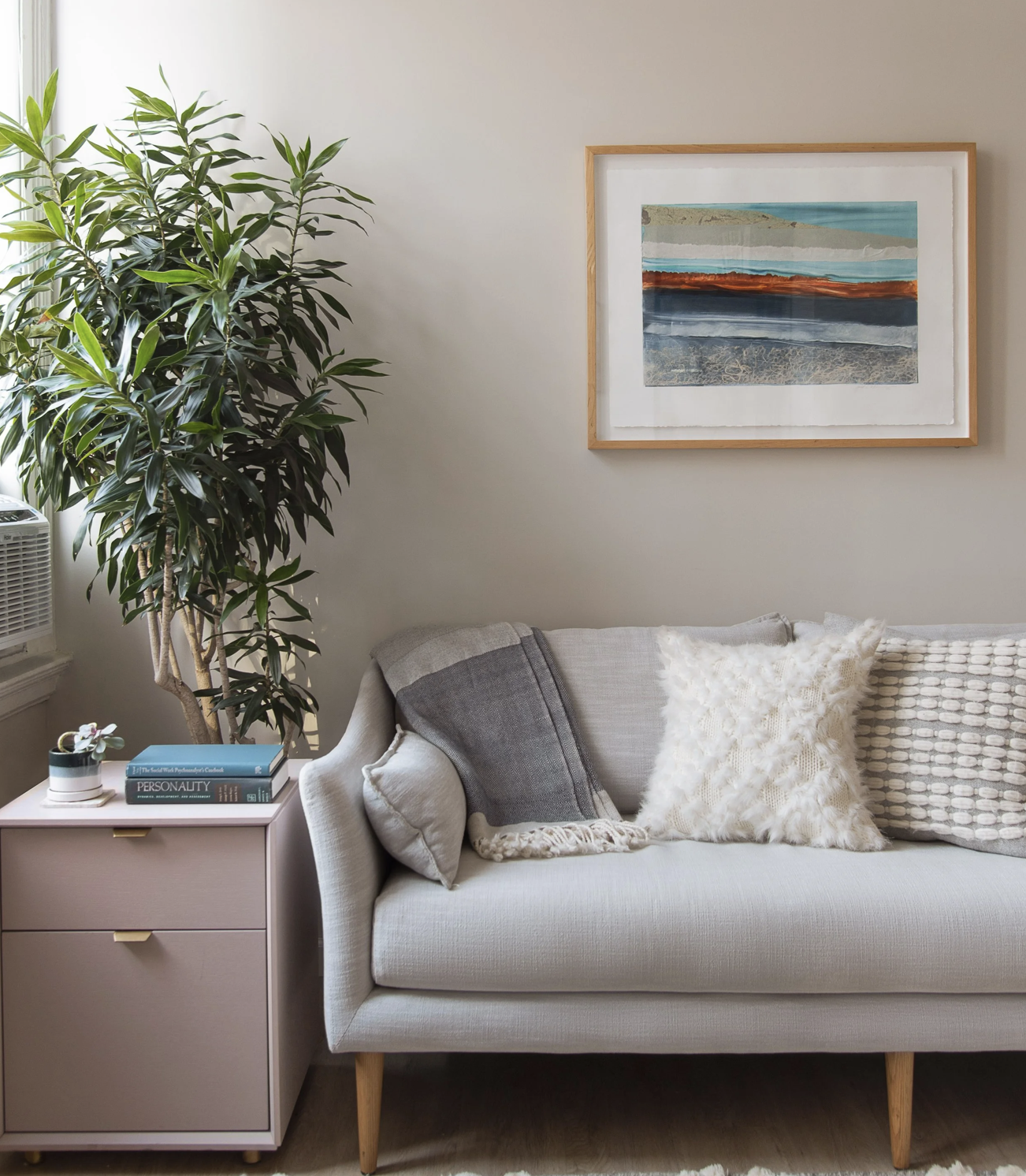A calm corner of the therapy office with a soft grey sofa and textured pillows