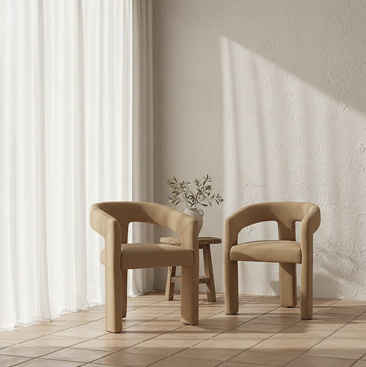 Two rounded, sand-colored armchairs facing each other beside a small wooden table in a sunlit room